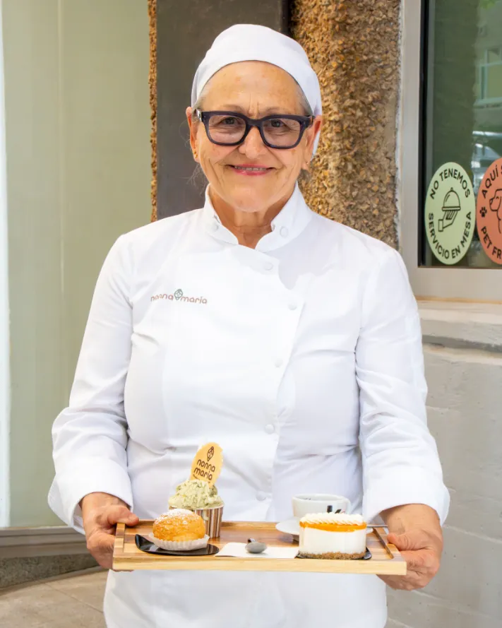 La nonna con una bandeja de dulces y un gelato frente a la tienda